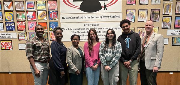 Group of diverse students standing in front of boardroom